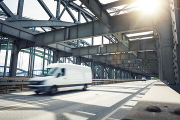 Van driving over an industrial style bridge