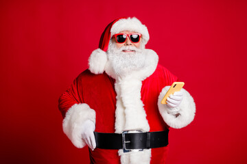 Portrait of his he nice handsome attractive cheerful bearded Santa using device 5g blogging comment media multimedia congratulation isolated bright vivid shine vibrant red color background