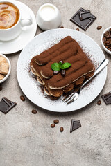 Classic tiramisu dessert, cup of coffee, sugar and milk on concrete background