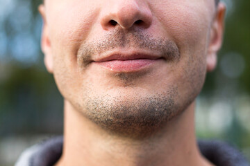 Beautiful male lips of Caucasian appearance close-up. The slight smile and the bristle of stubble...
