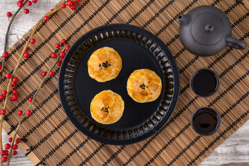 Moon cake yolk pastry, mooncake for Mid-Autumn Festival holiday, top view design concept on bright wooden table with copy space, flat lay, overhead shot