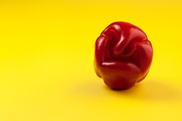 Ugly red bell pepper on yellow background with copy space. Concept - reduction of food organic...