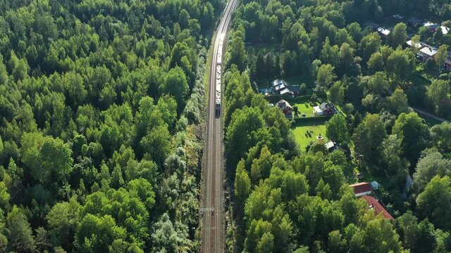 Aerial view of the high-speed commuter train moves on the railroad in the countryside in Espoo, Finland.