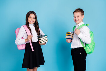 Photo of two small girl boy schoolchildren brother sister classmates hold pile books library study...