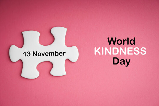 WORLD KINDNESS DAY  text with white jigsaw puzzle on pink background