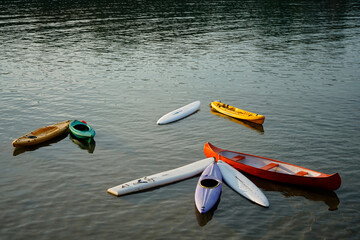Several boats, canoes and sups tied together in the water