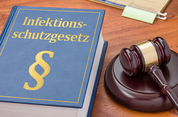 Gesetzbuch mit Richterhammer - Infektionsschutzgesetz