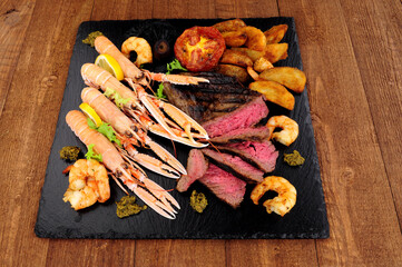 Surf and turf meal with sirloin steak, langoustine and tiger prawns