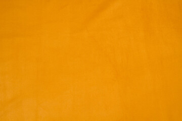 Ocher matte background of suede fabric, closeup. Velvet texture of seamless yellow leather.	
