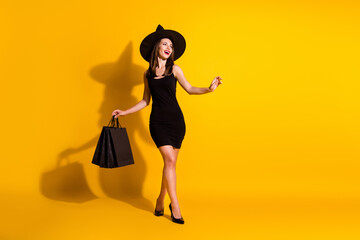 Fototapeta na wymiar Full length body size view of her she nice attractive pretty thin cheerful cheery rich wealthy chic lady wizard carrying new things clothes isolated bright vivid shine vibrant yellow color background