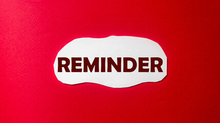 Reminder, text is written on a piece of paper and a red background. Do not forget