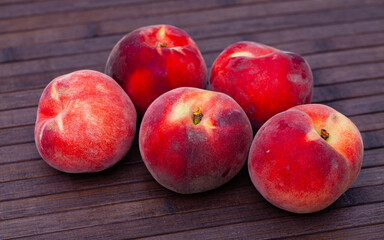 Fototapeta na wymiar Delicious ripe peaches fruit on wooden surface close up