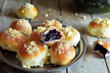 Sweet buns with berries on a wooden background