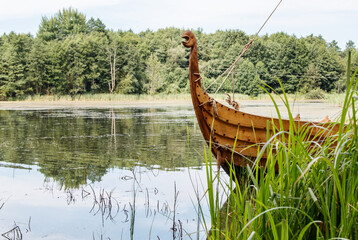 old wooden viking boat by the lake - obrazy, fototapety, plakaty