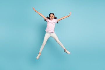 Fototapeta na wymiar Full length body size view of her she nice attractive pretty carefree foolish cheerful cheery pre-teen girl jumping having fun fooling isolated over blue pastel color background