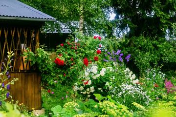 Naklejka na ściany i meble Pretty blooming garden with gazebo
