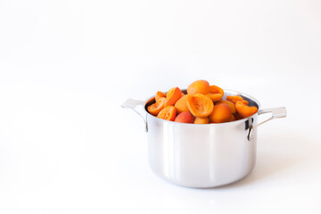 
Fresh apricots in a pot for homemade apricot jam against a white background.
Frische Marillen im Topf für selbstgemachte Apricosen Konfitüre vor weißem Hintergrund. 