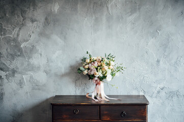 wedding bouquet on dresser near gray wall with vintage texture