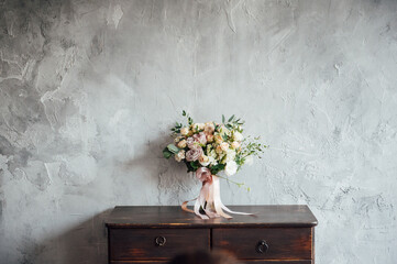 wedding bouquet on dresser near gray wall with vintage texture