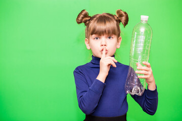 Funny little girl with shocked face and hand near head holding plastic bottles and looking confused at camera isolated over green