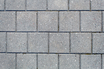 road paved with sidewalk tiles. texture of light gray bricks.