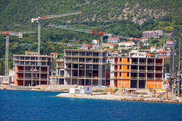 Coastal Construction Site . Construction of new hotels in Kotor Bay . Working cranes 