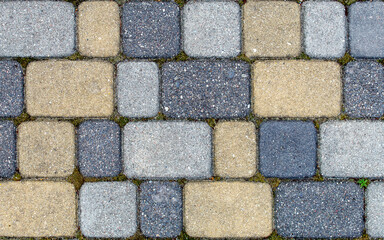 Fototapeta premium road paved with sidewalk tiles. texture of yellow, light and dark gray bricks.