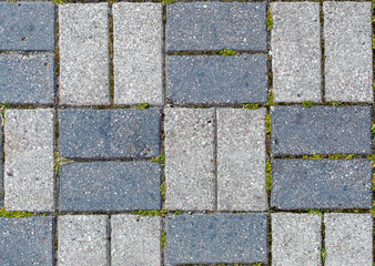 road paved with sidewalk tiles. texture of light and dark gray bricks.