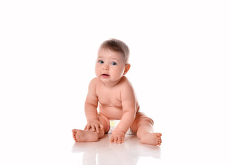 Cute little baby wearing diapers sitting on floor