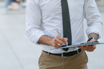 construction engineer standing holding agreement documents papers inspecting project development at the construction site