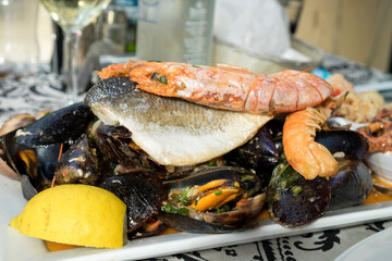 The plate of maltese seafood - freshly caught and grilled octopus tentacles, calamari rings in tempura, giant shrimps, clams, fish fillets and mussels