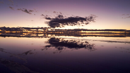 Fototapeta na wymiar Reflection of sunrise in Salar de Uyuni in Bolivia