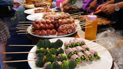 Traditional Asian night street food market in Thailand. Barbecue meatballs and other exotic delicious snacks for sail. Ready to eat food