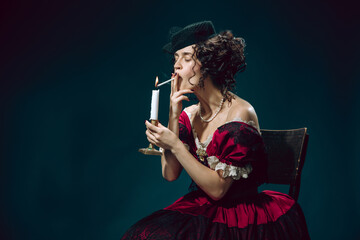 Secretly smoking. Young woman as Anna Karenina isolated on dark blue background. Retro style,...