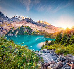 Exciting morning view of unique Oeschinensee Lake. Colorful summer sunrise in Swiss Alps with...