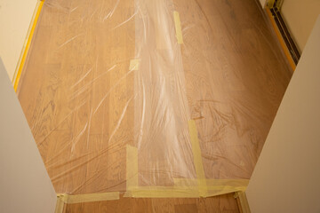 Oak floor covered with transparent plastic film