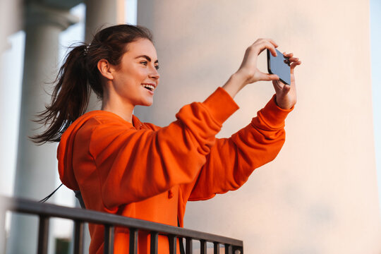 Image of joyful nice woman taking selfie photo on cellphone and smiling