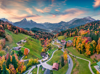 Fantastic evening view from flying drone of Maria Gern church with Hochkalter peak on background. Incredible autumn scene of Bavarian Alps. Colorful landscape of Germany countryside.