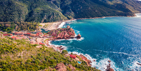 Fototapeta premium Panoramic view from flying drone of Porto town with Genoise de Porto Ota tower. Aerial summer scene of Corsica island, France, Europe. Traveling concept background..