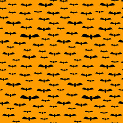 Seamless cute Halloween pattern with small and big flying black bats on orange background. Holiday print for fabric textile gift paper scrapbook wallpaper kids crafts