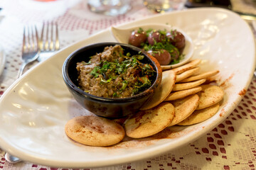Maltese appetizer - beer snack with hot stewed beans, soft eggplant pate, salty crackers and toasted bread with garlic and herbs 