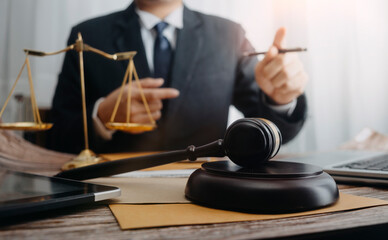 Businessman and lawyers discussing contract papers with brass scale on desk in office. Law, legal services, advice, justice and law concept picture with film grain effect