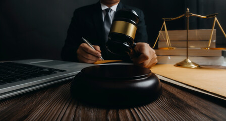Businessman and lawyers discussing contract papers with brass scale on desk in office. Law, legal services, advice, justice and law concept picture with film grain effect