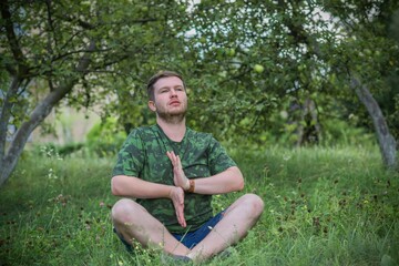 Naklejka na ściany i meble Young meditative guy at nature. People of new world, changing time