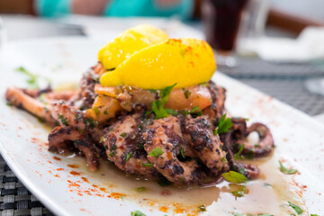 Delicious dish from traditonal cuisine of Malta island - freshly caught octopus grilled with garlic and olive oil and served with wine sauce