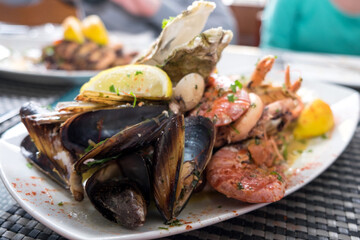 Delicious seafood platter from Malta  - freshly caught and grilled octopus tentacles, calamari rings in tempura, giant shrimps, clams, fish fillets and mussels 