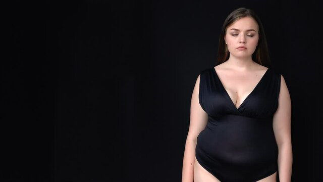 Plus-size beautiful lady sadly looking at camera, place for your adv, template