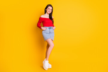 Full length body size view of her she nice-looking attractive lovely slender cheerful brown-haired girl posing wearing red top isolated over bright vivid shine vibrant yellow color background