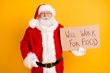 Portrait of his he nice cheerful white-haired Santa holding in hands paper card promo will work for food industry economy anti crisis plan isolated bright vivid shine vibrant yellow color background