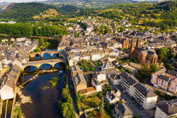 Scenic aerial view of French commune of Espalion on banks of Lot river with medieval Parish Church...